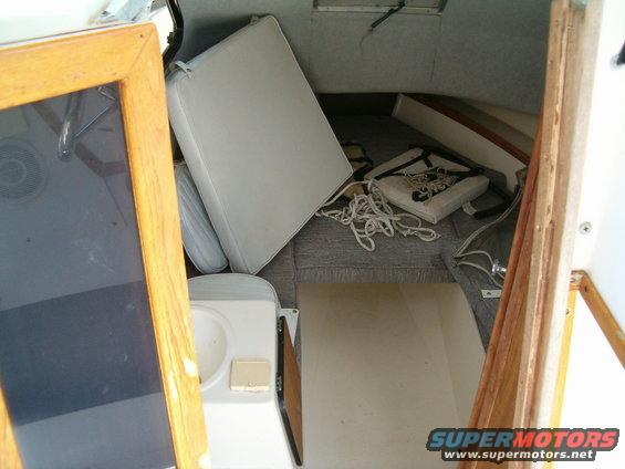 Interior of a vehicle with debris and damaged upholstery visible through an open door