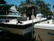 1991 Ford Bronco - Multiple boats are docked outdoors under a bright sky with trees in the background.