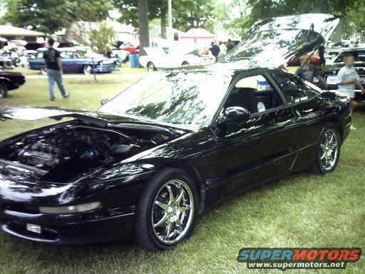 Black 1995 Ford Probe with hoods open, parked on grass at an outdoor event