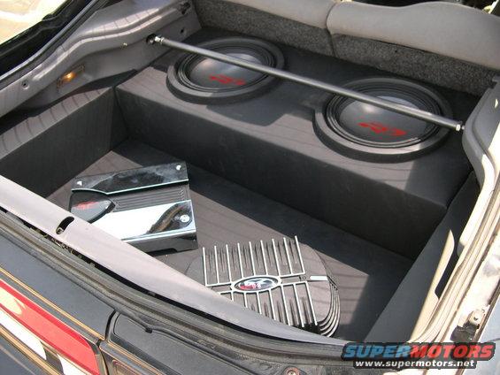 car trunk with two subwoofers, an amplifier, and a heat sink