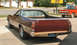1972 Ford Ranchero - Rear view of a brown 1972 Ford Ranchero pickup truck parked outdoors, with a red Chevrolet pickup in the background.