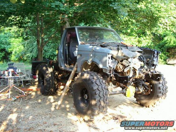 Modified off-road truck with large tires and damaged front end