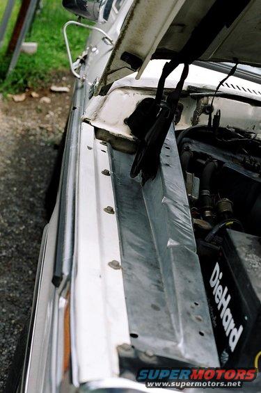 White car engine bay, hood open. DieHard battery visible