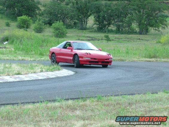 red 1993 Ford Probe on a race track, turning a corner