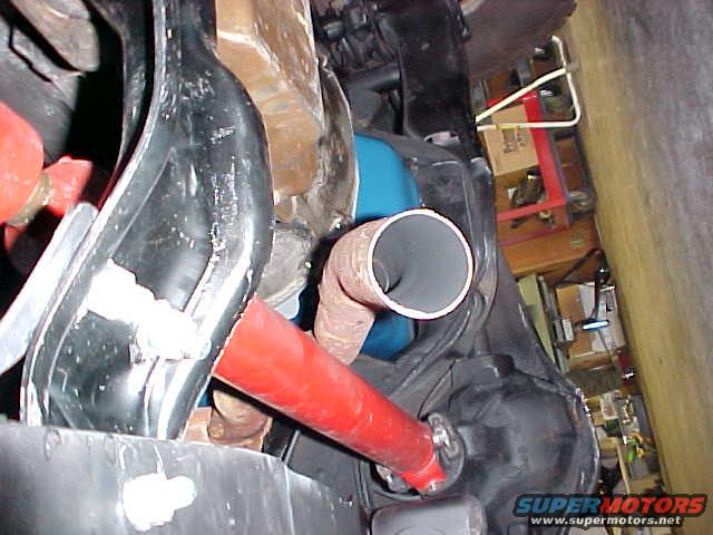 Undercarriage of a vehicle with a red exhaust pipe and black plastic components