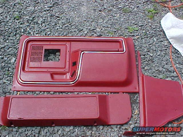 Red interior door panels and trim pieces on gravel
