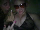 Two women posing for a selfie, one giving the middle finger