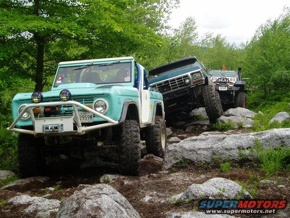 Teal 1969 Ford Bronco and two other off-road vehicles navigating a rocky trail