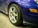 2004 Ford Focus - The wheel and fender of a blue car are shown, with the SVT logo visible on the wheel hub.