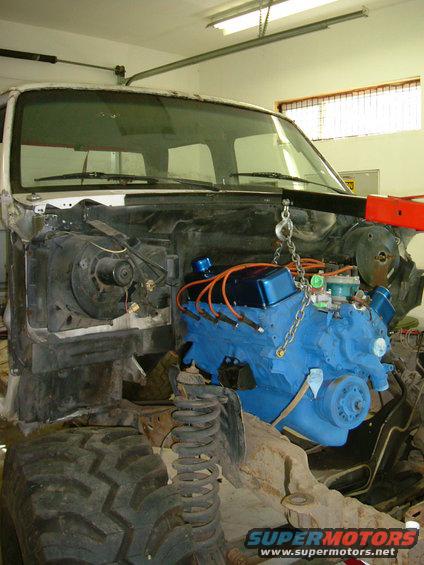 1995 Ford F-150 engine bay with blue engine being lowered in