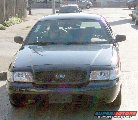 Black 2003 Ford Crown Victoria, front view, parked on street, two people inside