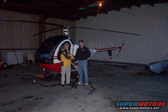 Helicopter with two men inside a hangar