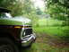 1974 Ford F-250 - A two-tone Ford F-Series truck sits in a grassy yard with trees and a fence in the background.