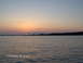 1978 Ford Bronco - The sun sets over a calm body of water, casting a warm glow across the sky.