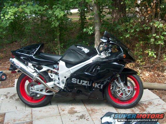 Black 2002 Suzuki TL1000R motorcycle with red rims parked on a patio
