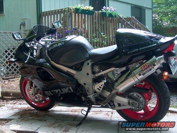 Black Suzuki sportbike with red rims and Yoshimura exhaust parked outside