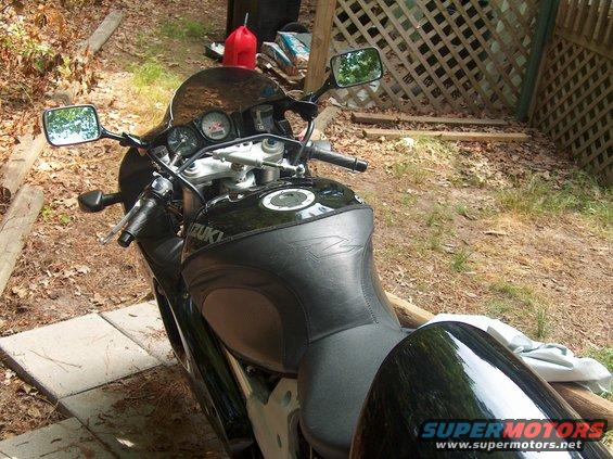 Black Suzuki motorcycle, 3q-front view. Visible 'SUZUKI' text on tank