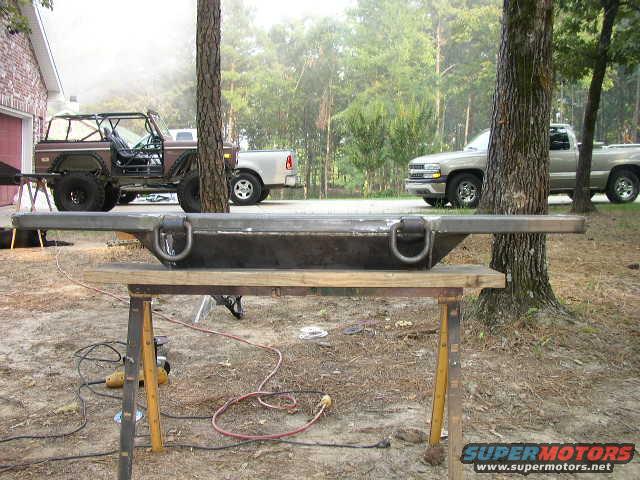 Metal bumper with D-rings on sawhorses, 1995 Ford Bronco and pickup truck in background