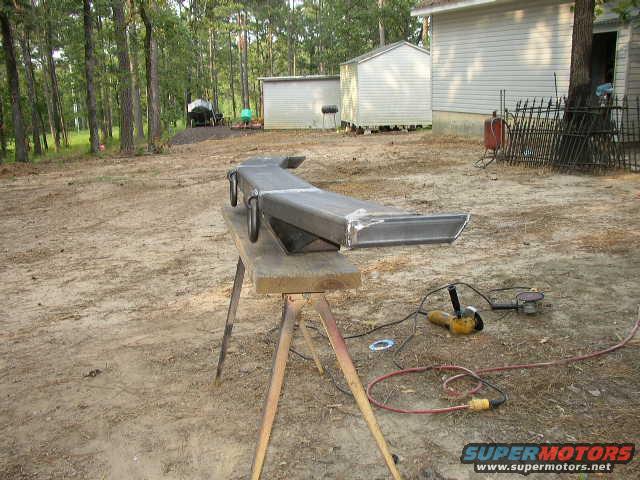 Metal bumper on sawhorses with grinder and sander nearby