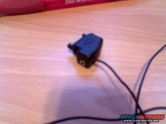black electronic part with wires on a wooden surface