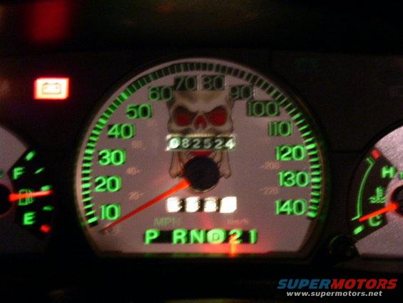 Dashboard gauges with a skull decal over the odometer reading 082524. Gear selector shows P R N D 2 1
