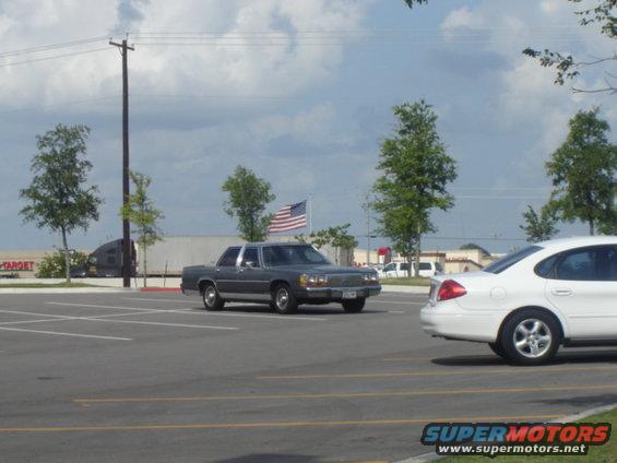 1988 Ford Crown Victoria LTD parked in a lot next to a white sedan