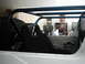 1978 Ford Bronco - The interior of a vehicle shows a roll cage and bucket seats, with a spare tire mounted behind the driver's side.