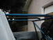 1978 Ford Bronco - Close-up view of a blue roll cage installed in a vehicle, with a spare tire visible to the right.