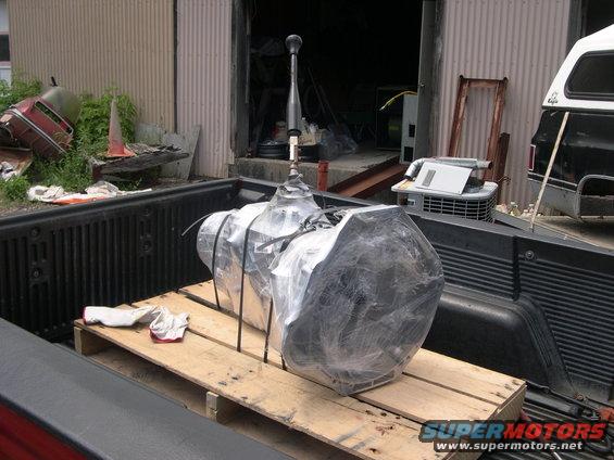 Transmission wrapped in plastic on a pallet in a pickup truck bed