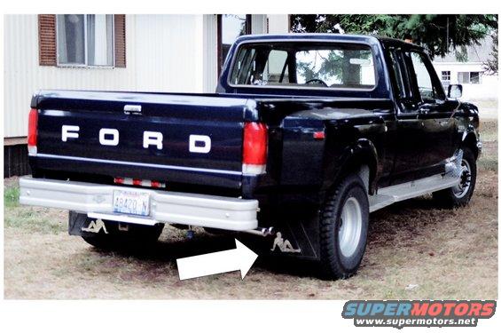 Dark blue Ford pickup truck rear view, chrome bumper, "FORD" tailgate lettering, mud flaps with silhouette
