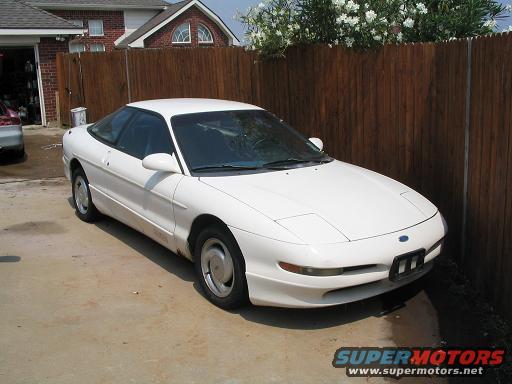 1994 Ford Probe parked in driveway, front 3/4 view. Watermark reads SUPERMOTORS.NET