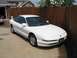 1994 Ford Probe - White 1994 Ford Probe parked in front of a wooden fence and garage.
