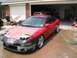 1994 Ford Probe - A red 1994 Ford Probe sits in a driveway, appearing to be in the middle of bodywork or repairs.