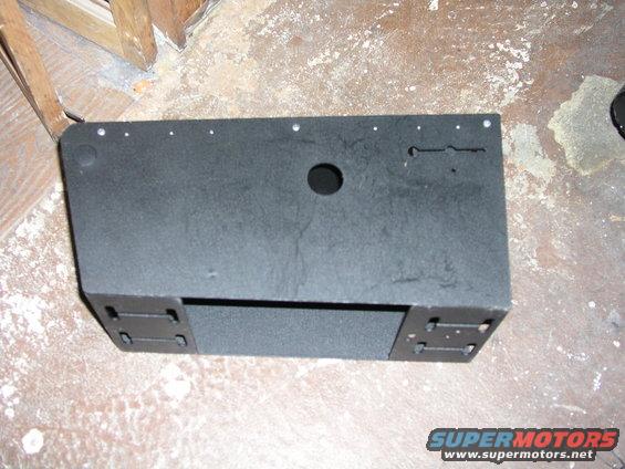 Black console part with mounting brackets and a central hole