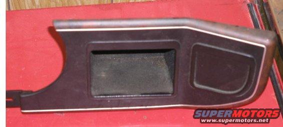 Dark brown interior trim piece with two openings and white trim