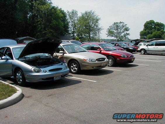 Silver 1997 Ford Taurus with hood open, parked in a lot