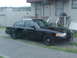1999 Ford Crown Victoria - A black 1999 Ford Crown Victoria police car is parked in front of a building.