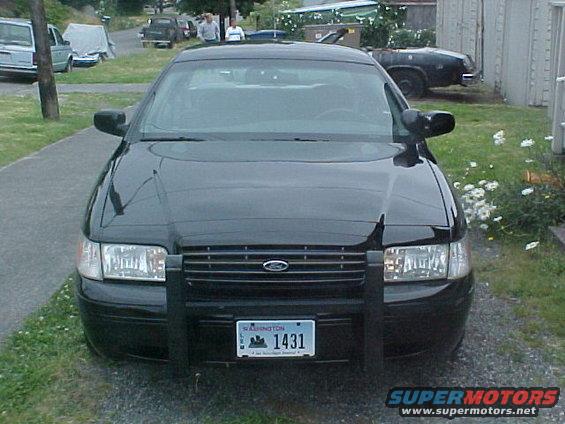 Black Ford Crown Victoria police car with push bar, front view. License plate reads 1431