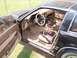 1984 Nissan 300ZX - The interior of a 1984 Nissan 300ZX shows brown seats and dashboard, an aftermarket steering wheel, and a camouflage seat cover.