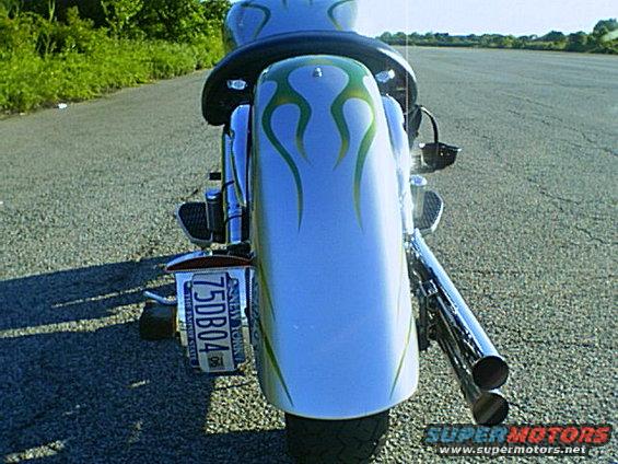 Motorcycle rear with blue and green flame decals on the fender and dual exhaust pipes