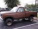 1979 Ford Bronco - Side view of a brown pickup truck, parked next to another vehicle.