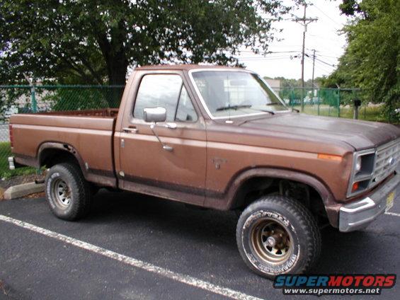 Brown pickup truck, 3/4 front view, parked in a lot