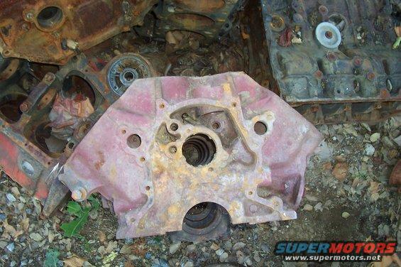 pile of old, rusty engine blocks and parts on the ground