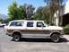 1988 Ford C-350 (Centurion Conversions) - Side profile of a white 1988 Ford C-350 Centurion Conversion van with woodgrain paneling.