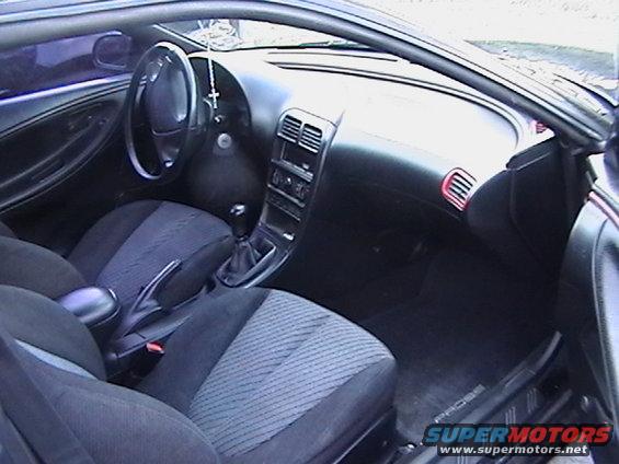 Interior view of a car with cloth seats and dashboard