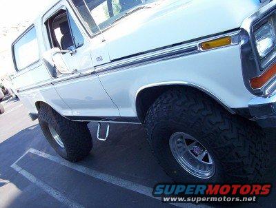 White Ford Bronco with aftermarket wheels and tires, viewed from the front quarter