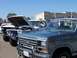 1995 Ford Bronco - Line of Ford trucks and Broncos at a car show, one with hood open.