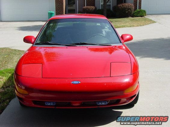 Red 1993 Ford Probe parked in front of a garage, front view