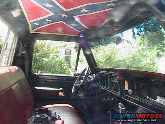 1977 Ford F-250 interior showing brown seats, dashboard, and Confederate flag headliner