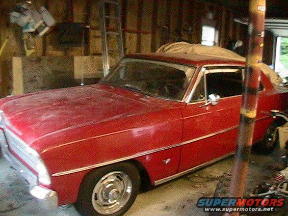 Red 1966 Chevrolet Nova coupe parked inside a garage